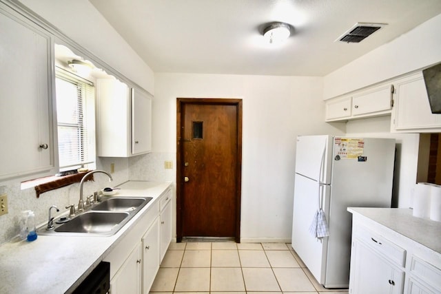 11931 Tanager St, Houston, TX 77072 - kitchen featuring freestanding refrigerator, white cabinetry, light countertops, light tile patterned flooring, and backsplash