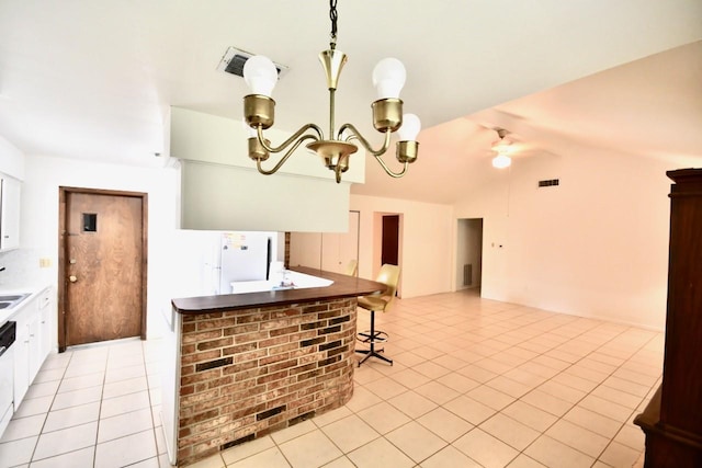 11931 Tanager St, Houston, TX 77072 - kitchen featuring ceiling fan, light tile patterned floors, lofted ceiling, white cabinetry, and freestanding refrigerator
