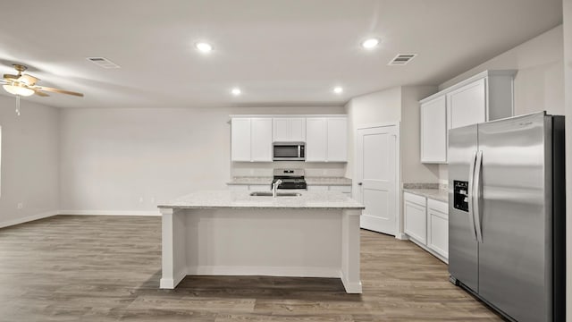 25021 Pomegranate Pl, Montgomery, TX 77316 - kitchen featuring appliances with stainless steel finishes, ceiling fan, white cabinets, wood finished floors, and recessed lighting