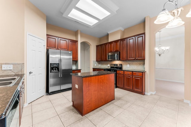 24910 Corbin Gate Dr, Spring, TX 77389 - kitchen with stainless steel appliances, arched walkways, a chandelier, a center island, and decorative backsplash