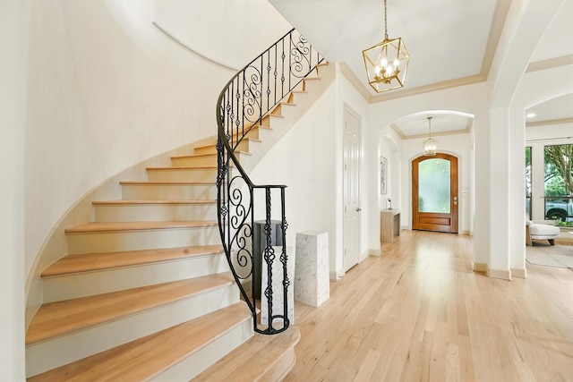 4106 Lehigh Ave, Houston, TX 77005 - foyer with arched walkways, a chandelier, wood finished floors, stairs, and ornamental molding