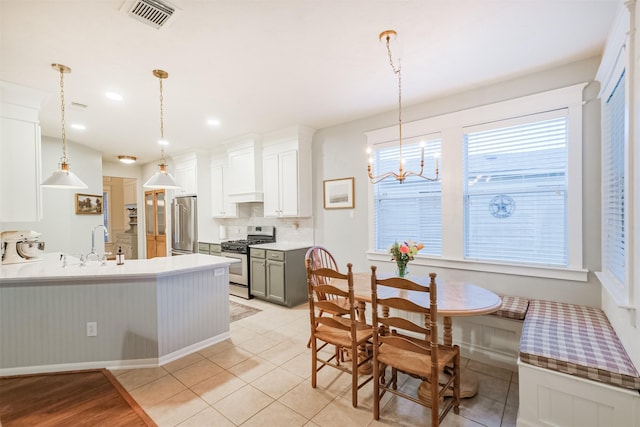 703 Rock Creek Ct, Rosenberg, TX 77469 - kitchen featuring appliances with stainless steel finishes, a peninsula, backsplash, a chandelier, and hanging light fixtures