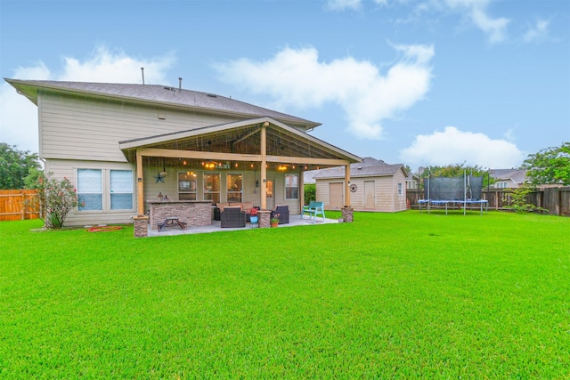 703 Rock Creek Ct, Rosenberg, TX 77469 - back of property with a trampoline, a patio area, a fenced backyard, and a storage unit