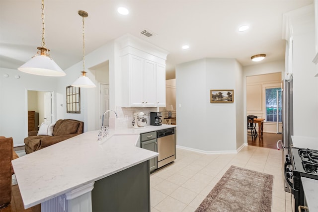 703 Rock Creek Ct, Rosenberg, TX 77469 - kitchen with dishwasher, a peninsula, gas stove, backsplash, and white cabinets