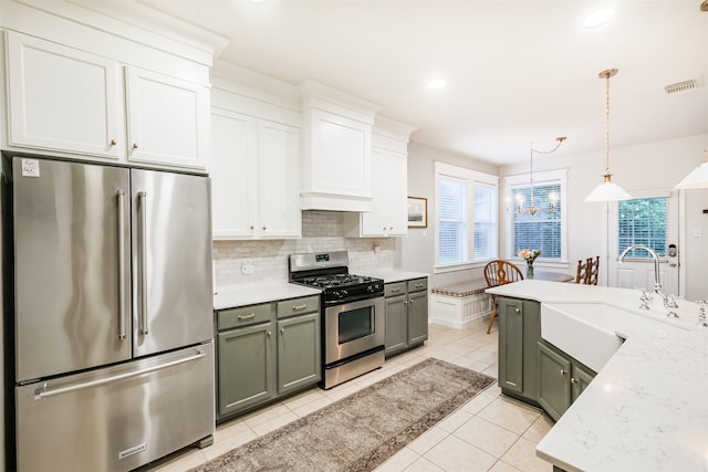 703 Rock Creek Ct, Rosenberg, TX 77469 - kitchen featuring stainless steel appliances, light tile patterned floors, backsplash, decorative light fixtures, and a chandelier
