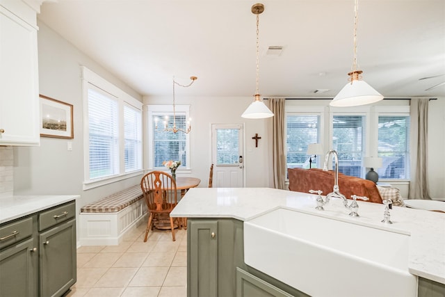 703 Rock Creek Ct, Rosenberg, TX 77469 - kitchen featuring healthy amount of natural light, light tile patterned flooring, decorative light fixtures, and gray cabinets