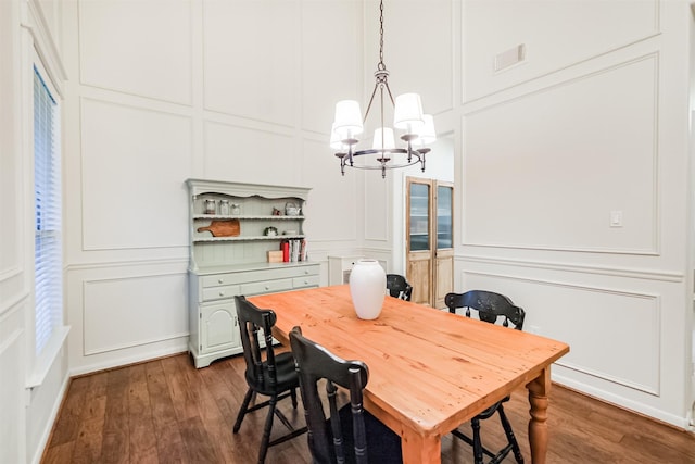 703 Rock Creek Ct, Rosenberg, TX 77469 - dining room with a decorative wall, a chandelier, and dark wood-style floors