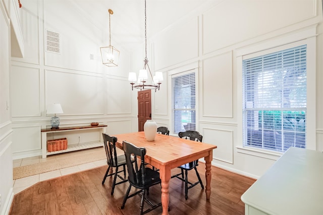 703 Rock Creek Ct, Rosenberg, TX 77469 - dining room with a decorative wall, a chandelier, and wood finished floors