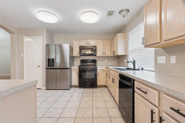 16306 Ancient Forest Dr, Humble, TX 77346 - kitchen featuring black appliances, light brown cabinetry, light countertops, arched walkways, and tasteful backsplash