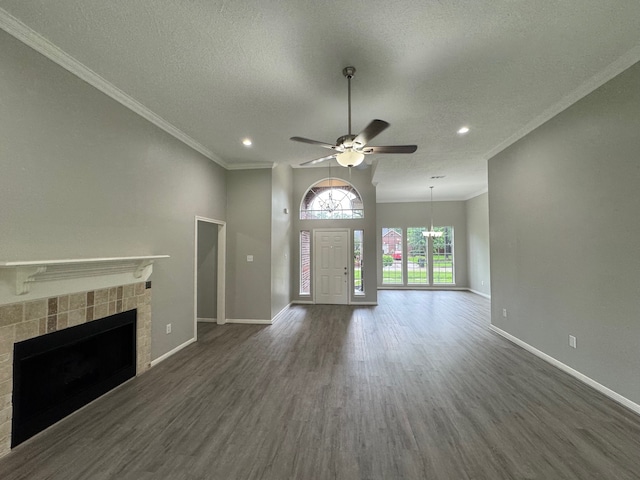 819 Companion Dr, Crosby, TX 77532 - unfurnished living room with wood finished floors, a tile fireplace, a textured ceiling, ornamental molding, and a ceiling fan