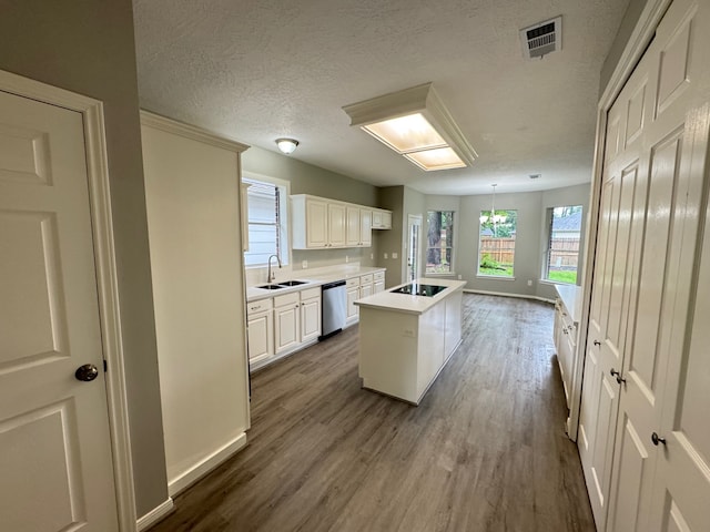 819 Companion Dr, Crosby, TX 77532 - kitchen featuring black electric cooktop, dishwasher, dark wood-type flooring, a textured ceiling, and light countertops