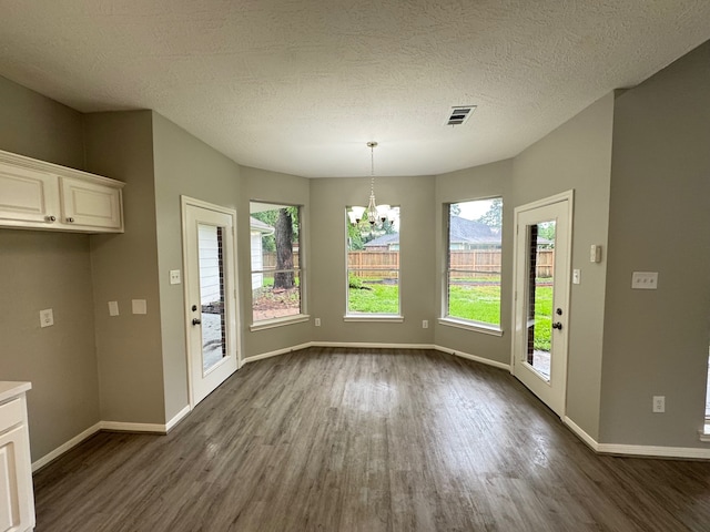 819 Companion Dr, Crosby, TX 77532 - unfurnished dining area with a chandelier, dark wood-type flooring, and a textured ceiling