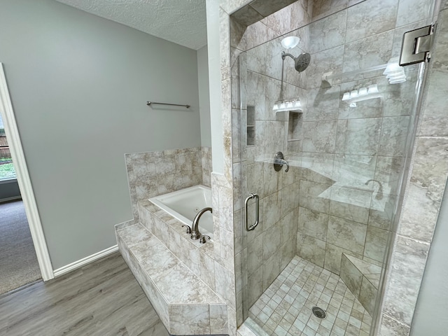 819 Companion Dr, Crosby, TX 77532 - full bathroom featuring a shower stall, a bath, wood finished floors, and a textured ceiling