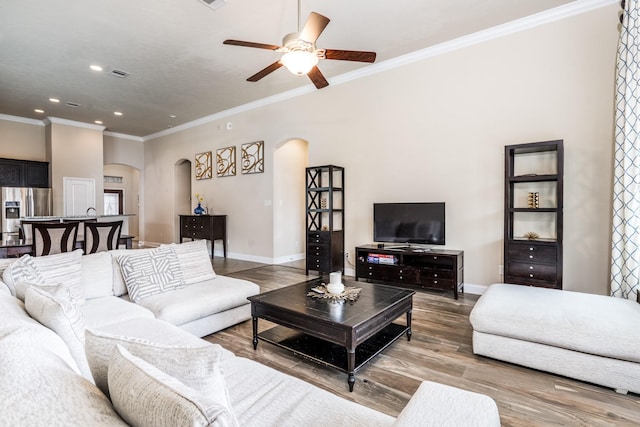 8506 Clarkman Ridge Ln, Cypress, TX 77433 - living area featuring arched walkways, wood finished floors, a ceiling fan, recessed lighting, and ornamental molding