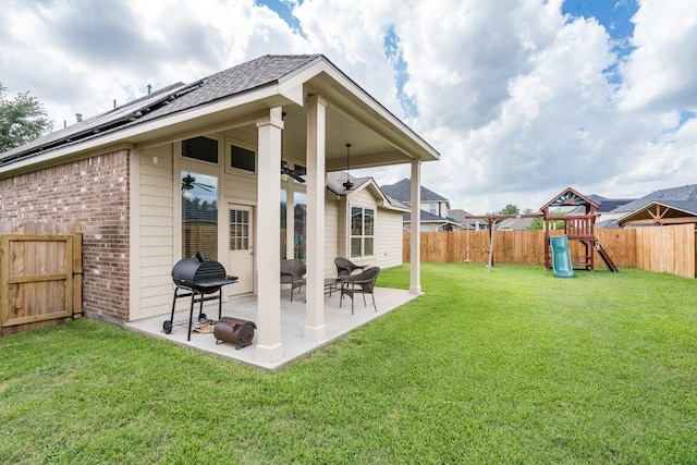 8506 Clarkman Ridge Ln, Cypress, TX 77433 - back of house with brick siding, a fenced backyard, a playground, a patio, and a shingled roof