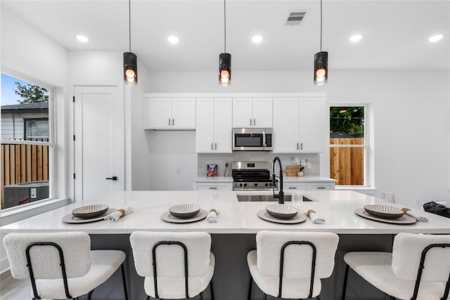 2475 Carmel St A/B, Unit A/B Houston, TX 77091 - kitchen featuring appliances with stainless steel finishes, white cabinetry, hanging light fixtures, light countertops, and recessed lighting