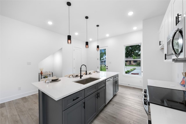 2475 Carmel St A/B, Unit A/B Houston, TX 77091 - kitchen featuring stainless steel appliances, white cabinetry, gray cabinetry, light wood-type flooring, and a kitchen island with sink