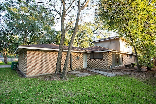 6407 Nuben St, Houston, TX 77091 - back of property with brick siding, a lawn, and a patio area