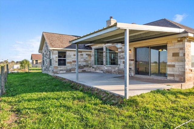2407 Thuesen Rd, Beasley, TX 77417 - rear view of property featuring a patio area, stone siding, a lawn, a chimney, and a shingled roof
