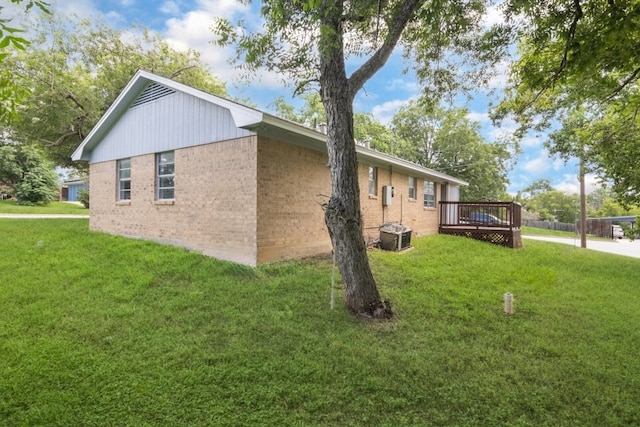 1314 Garrett St, Brenham, TX 77833 - view of home's exterior featuring brick siding, a wooden deck, and a yard