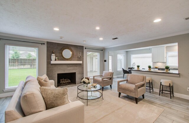 22523 Wildwood Grove Dr, Katy, TX 77450 - living area featuring ornamental molding, recessed lighting, a large fireplace, and light wood-style floors
