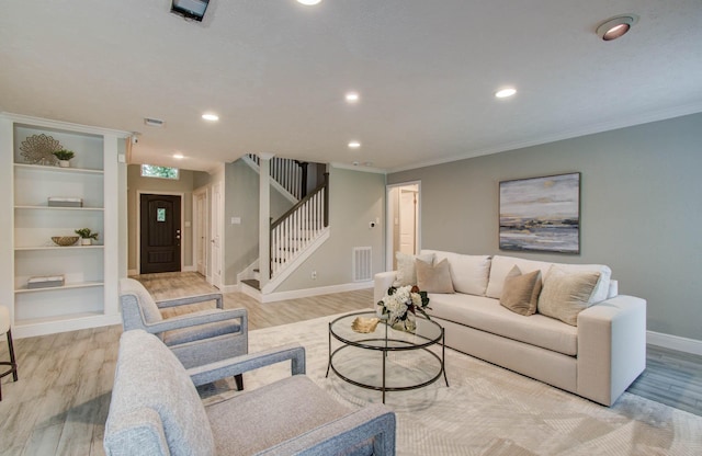 22523 Wildwood Grove Dr, Katy, TX 77450 - living area with stairs, light wood-style flooring, recessed lighting, ornamental molding, and built in shelves