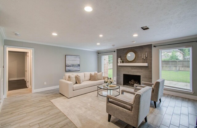 22523 Wildwood Grove Dr, Katy, TX 77450 - living area with healthy amount of natural light, light wood-type flooring, recessed lighting, a large fireplace, and ornamental molding