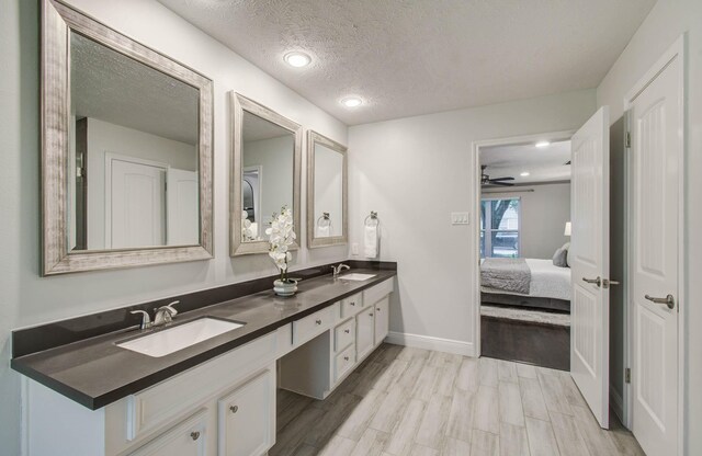 22523 Wildwood Grove Dr, Katy, TX 77450 - full bath with double vanity, wood finished floors, a textured ceiling, connected bathroom, and a ceiling fan