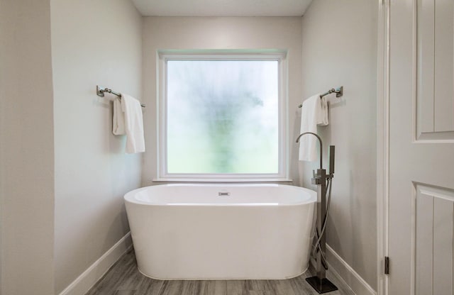 22523 Wildwood Grove Dr, Katy, TX 77450 - bathroom featuring a freestanding bath, healthy amount of natural light, and wood finished floors
