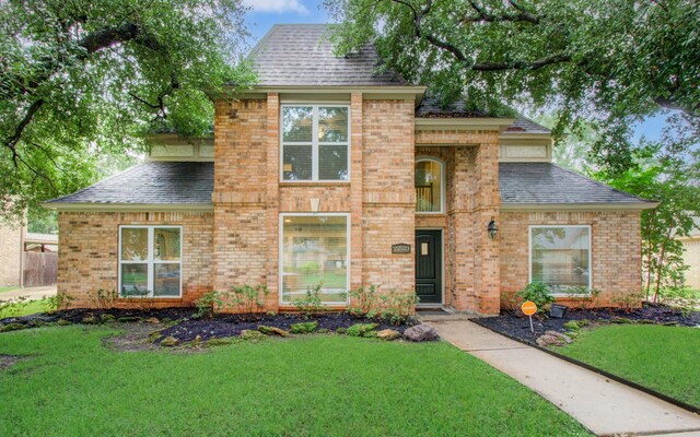 22523 Wildwood Grove Dr, Katy, TX 77450 - traditional home featuring a shingled roof, brick siding, and a front yard