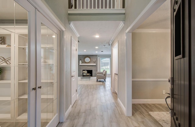 22523 Wildwood Grove Dr, Katy, TX 77450 - foyer with crown molding, light wood-type flooring, a fireplace, and french doors