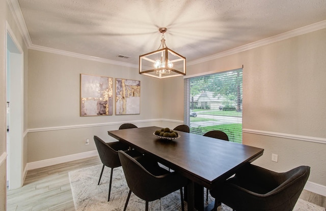 22523 Wildwood Grove Dr, Katy, TX 77450 - dining area with a chandelier, light wood-type flooring, crown molding, and a textured ceiling