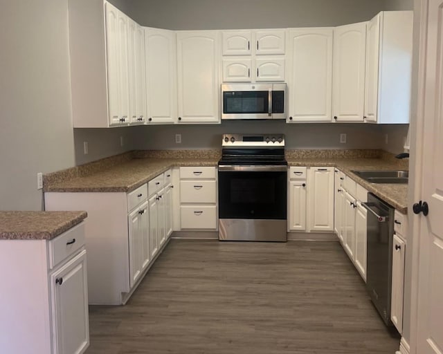 575 Hartman Rd, Silsbee, TX 77656 - kitchen featuring stainless steel appliances, dark wood-type flooring, and white cabinetry