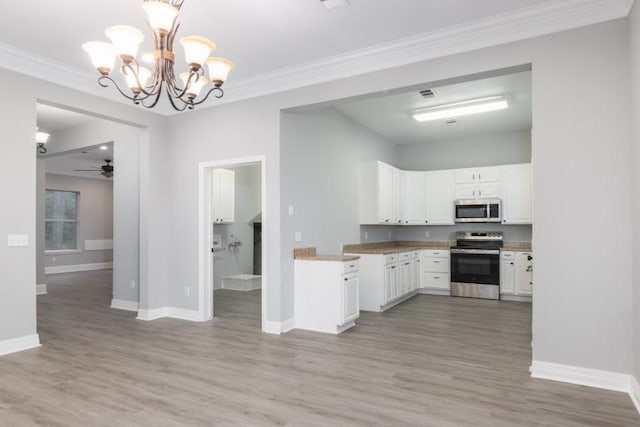 575 Hartman Rd, Silsbee, TX 77656 - kitchen featuring stainless steel appliances, white cabinets, a ceiling fan, light wood-style flooring, and ornamental molding