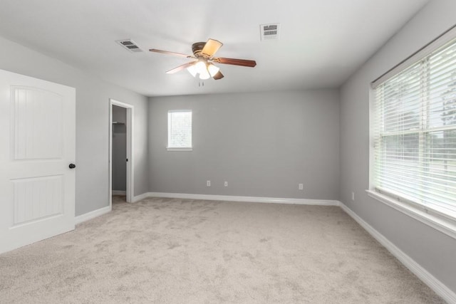 575 Hartman Rd, Silsbee, TX 77656 - unfurnished bedroom with light colored carpet, a walk in closet, and a ceiling fan