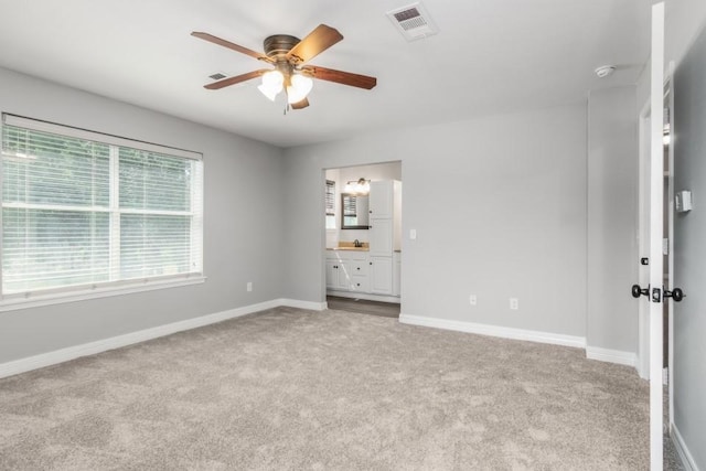 575 Hartman Rd, Silsbee, TX 77656 - unfurnished bedroom with carpet floors, ensuite bathroom, and a ceiling fan