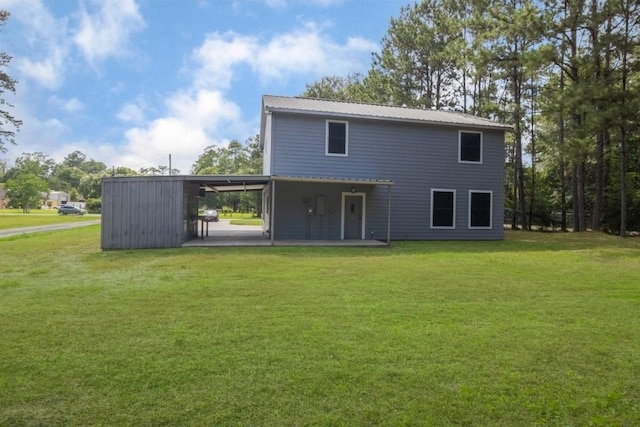 575 Hartman Rd, Silsbee, TX 77656 - rear view of house featuring a yard, a patio area, a carport, and a metal roof