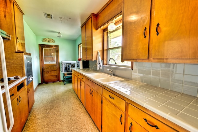 1726 Wilde Rock Way, Houston, TX 77018 - kitchen featuring tile counters, tasteful backsplash, and brown cabinetry