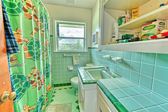 1726 Wilde Rock Way, Houston, TX 77018 - bathroom featuring tile patterned floors, vanity, tile walls, curtained shower, and a wainscoted wall