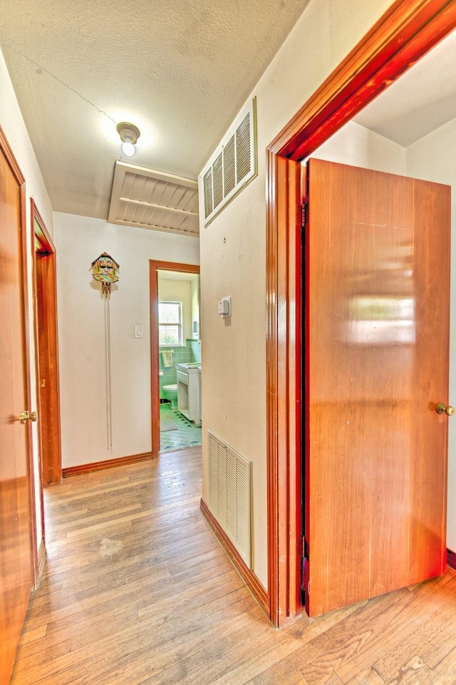 1726 Wilde Rock Way, Houston, TX 77018 - hallway featuring wood finished floors, attic access, and a textured ceiling
