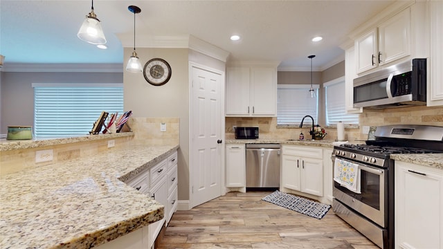 2010 Wildwood Dr, Deer Park, TX 77536 - kitchen with appliances with stainless steel finishes, ornamental molding, light wood-style floors, decorative backsplash, and white cabinetry