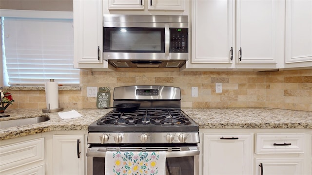 2010 Wildwood Dr, Deer Park, TX 77536 - kitchen with stainless steel appliances, white cabinets, tasteful backsplash, and light stone countertops