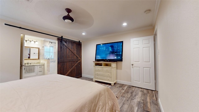 2010 Wildwood Dr, Deer Park, TX 77536 - bedroom with a barn door, wood finished floors, ornamental molding, connected bathroom, and recessed lighting