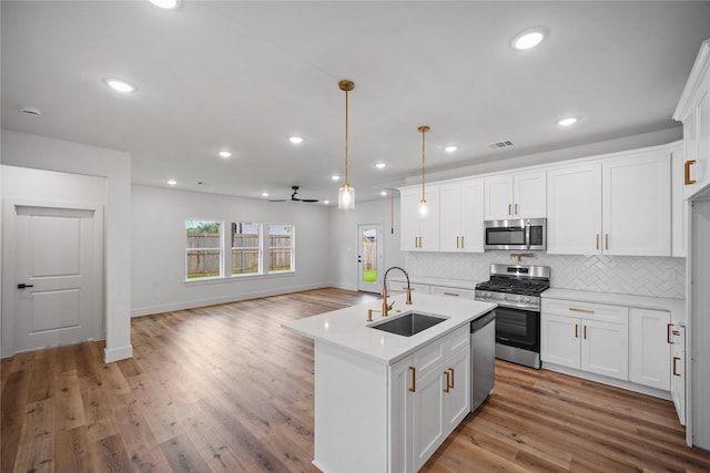 19219 Hikers Trail Dr, Humble, TX 77346 - kitchen featuring appliances with stainless steel finishes, light countertops, backsplash, white cabinets, and a ceiling fan