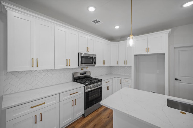 19219 Hikers Trail Dr, Humble, TX 77346 - kitchen featuring stainless steel appliances, white cabinetry, light stone countertops, decorative light fixtures, and recessed lighting