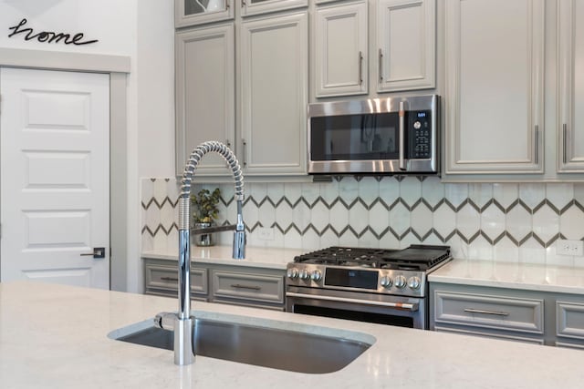 152 E Shell Port Sq, The Woodlands, TX 77380 - kitchen featuring appliances with stainless steel finishes, gray cabinetry, and light stone countertops