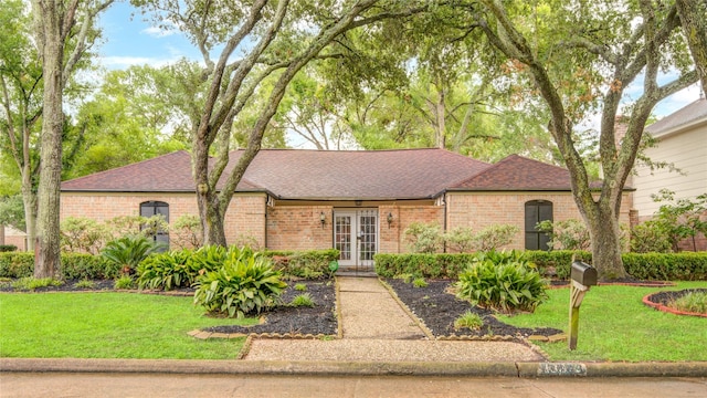 13903 Chevy Chase Dr, Houston, TX 77077 - view of front of property with french doors, brick siding, a front yard, and roof with shingles