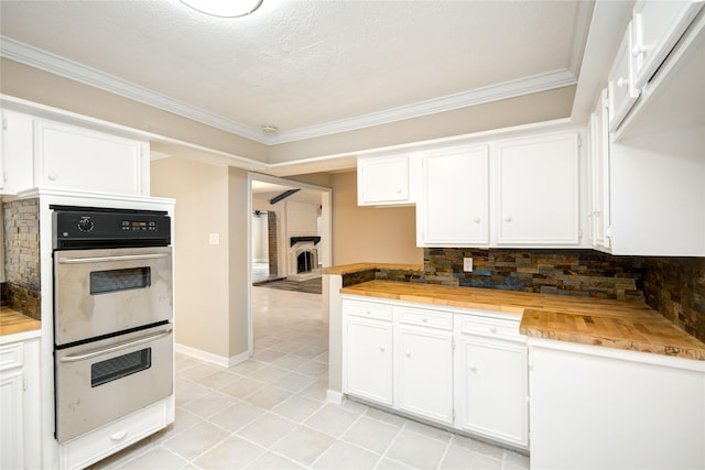 13903 Chevy Chase Dr, Houston, TX 77077 - kitchen featuring wooden counters, stainless steel double oven, white cabinets, crown molding, and backsplash