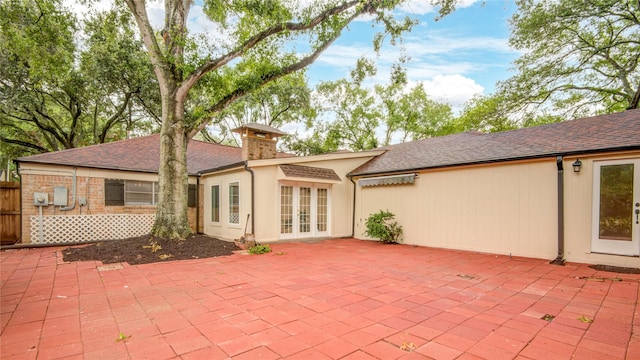 13903 Chevy Chase Dr, Houston, TX 77077 - rear view of property featuring french doors, a patio area, roof with shingles, and a chimney