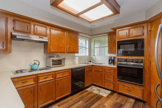 3701 Regency Dr, Deer Park, TX 77536 - kitchen featuring black appliances, under cabinet range hood, light countertops, and dark wood finished floors